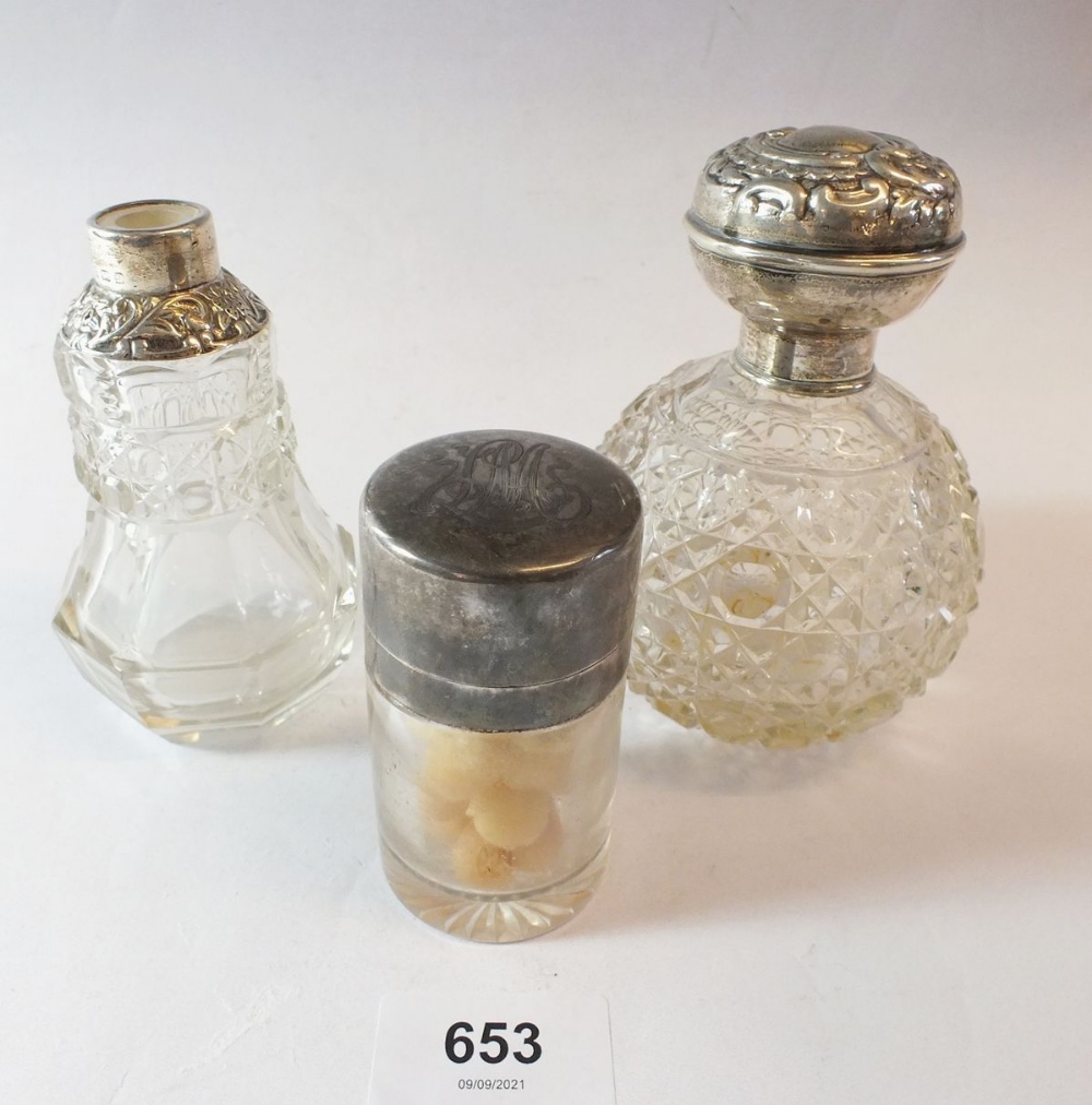 A silver smelling salts jar, Birmingham 1912 and two silver capped scent bottles