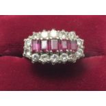 An 18 carat gold ring set five baguette cut rubies in diamond surround, size P