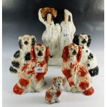 A Victorian Staffordshire figure group, four various Staffordshire dogs and a smaller one