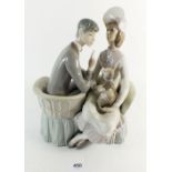 A Lladro figurine of a man and woman sitting holding a dog, 26.5cm high