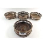 Four silver plate on copper bottle coasters with turned wooden bases, 12cm diameter