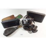 A No 3 Kodak camera , an Eastman Kodak camera, a Iloca camera and a leather powder flask