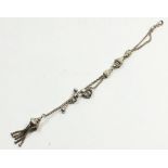 An antique ladies silver watch chain stamped 'real silver' embossed decoration and tassel, 18g