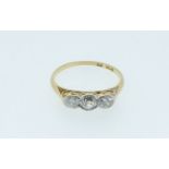 An early 20th century 18 carat gold three stone diamond ring, the central old cut diamond