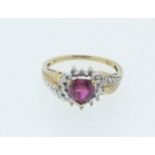 A 10ct gold ring set with heart shaped ruby and flanking diamonds, size Q, 2.5g