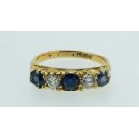 An 18 carat gold ring set three sapphires and two diamonds, size L, 3.2g