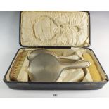 A silver dressing table set with mirror and three brushes, Birmingham 1925, case a/f