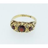 An 18 carat gold garnet and chip diamond ring, size J-K