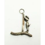 A miniature white metal moving charm with monkey sawing a log