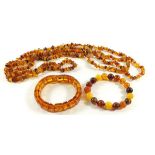 Two amber bracelets and a chip amber necklace, combined weight 65g