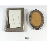 A silver photograph frame, 11cm x 8cm and an oval floral embossed white metal frame