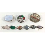 A silver stone set bracelet and three white metal brooches