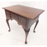 A George III mahogany lowboy on cabriole supports