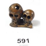 A signed carved wood netsuke in the form of two skulls
