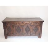 An early 18th century elm coffer with four panel lozenge carved front all on stile supports, 150 x
