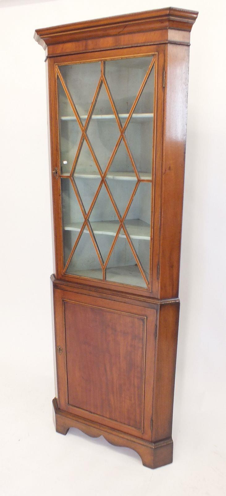 A 19th century Georgian style mahogany glazed corner cabinet with glazed door over cupboard