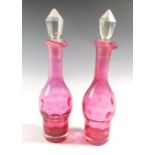 A pair of Victorian cranberry glass cruet bottles