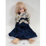 A bisque headed doll with composition body, blue fixed eyes, blonde hair in dark blue silk dress