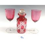 A pair of cranberry wine glasses and a flashed and cut glass scent bottle