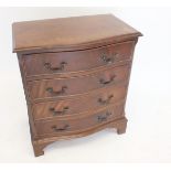 A reproduction mahogany serpentine fronted mahogany small chest of four drawers