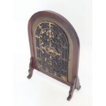 A mahogany framed arch top firescreen with applied cast iron gilt and silvered panel