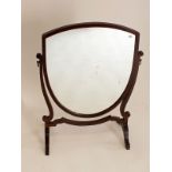 A shield form mahogany toiletry mirror