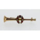 An Edwardian 9ct gold brooch in the form of a hunting horn set with a horseshoe studded with