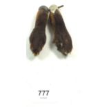 Two taxidermy fox paws with white metal mounts, engraved 1927 and Orcop 1926