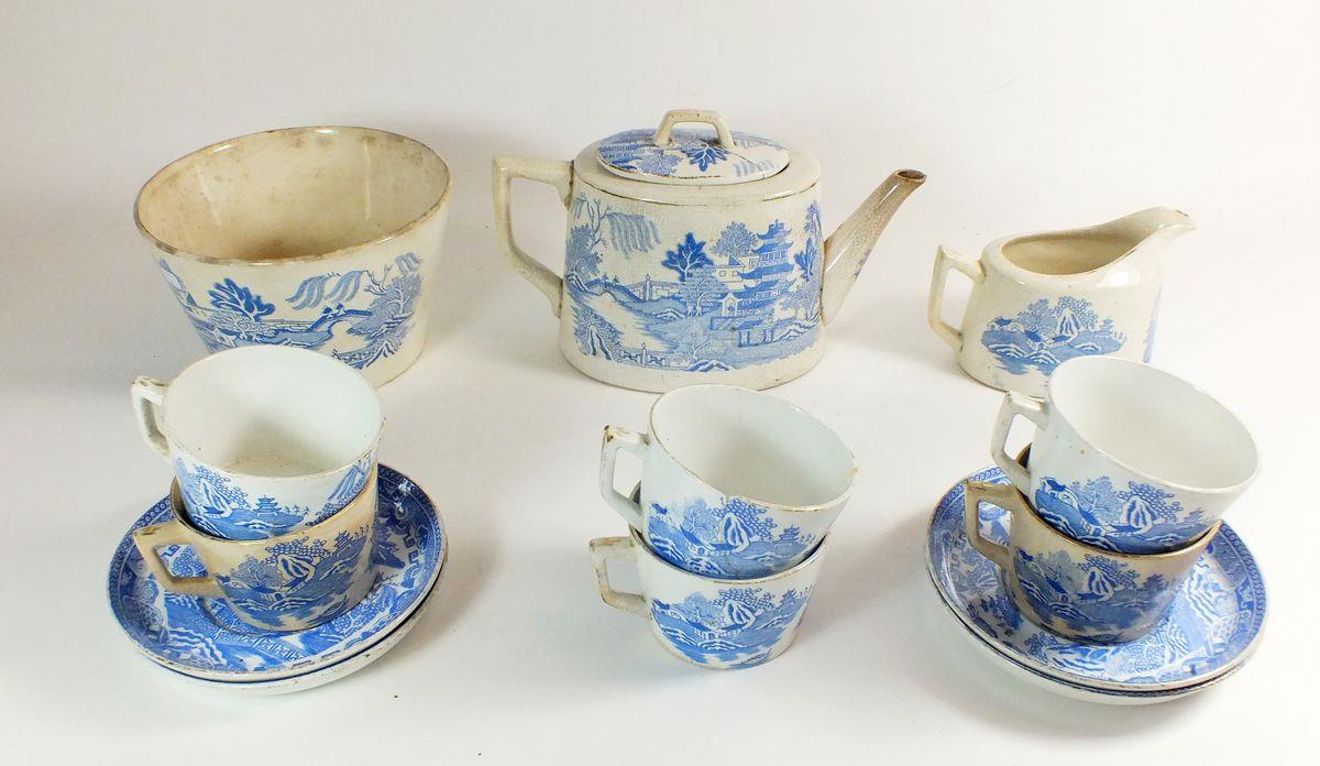 An early 19th century Willow pattern tea service comprising: teapot, jug, slop bowl, six cups and