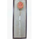 A 19th century yellow metal stick pin set carved coral cameo of a woman, in fitted case