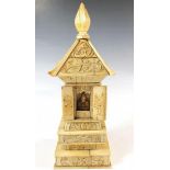 A 19th century Chinese carved bone pagoda opening to reveal seated figure, 21cm