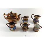 A Victorian copper lustre teapot, four jugs and a mug