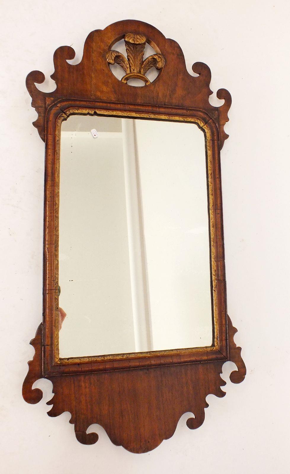 A George III walnut mirror with fretwork surround and gilt fleur de lys surmount