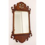 A George III walnut mirror with fretwork surround and gilt fleur de lys surmount