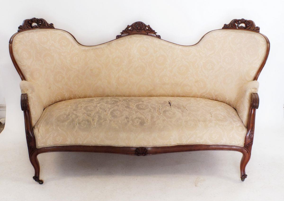 A Victorian triple arch back settee with scrollwork carved decoration, scroll over arms and supports