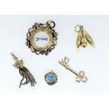 A gold plated compass form fob and four various gold plated charms