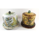 Two Victorian Majolica cheese domes, one marked Adderley with fern design and the other with flowers