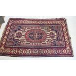 A Russian Sournak rug with geometric design on red and blue ground, 210 x 142cm
