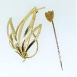 A 9 carat gold floral spray brooch and an Edwardian 9 carat gold stick pin, combined weight 4g