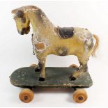 A 19th century painted wood pull along toy horse on wheels, 31cm x 29cm