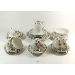 An Austrian floral printed part tea service comprising: seven tea cups, nine saucers, nine side