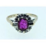 An 18 carat white gold ruby and diamond cluster ring with baguette and brilliant cut stones, size J