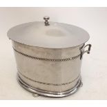 A large stainless steel oval coal scuttle with domed lid and liner