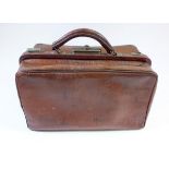 An antique Gladstone bag with red leather lining