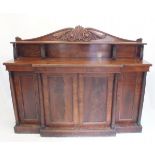 An early 19th century mahogany chiffonier with low back raised on stiff leaf carved supports, all