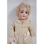 A late 19th century bisque headed doll with jointed composition body, blue sleeping eyes and open