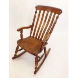 A 19th century elm seated rocking chair with slat back