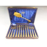 A Cyril Russell gilt finish fish cutlery set in oak case