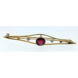 A 9ct gold bar brooch set with seed pearls and a central red stone, cased
