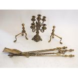 A brass candelabra and three piece fire iron set, a pair of fire dogs and toasting fork